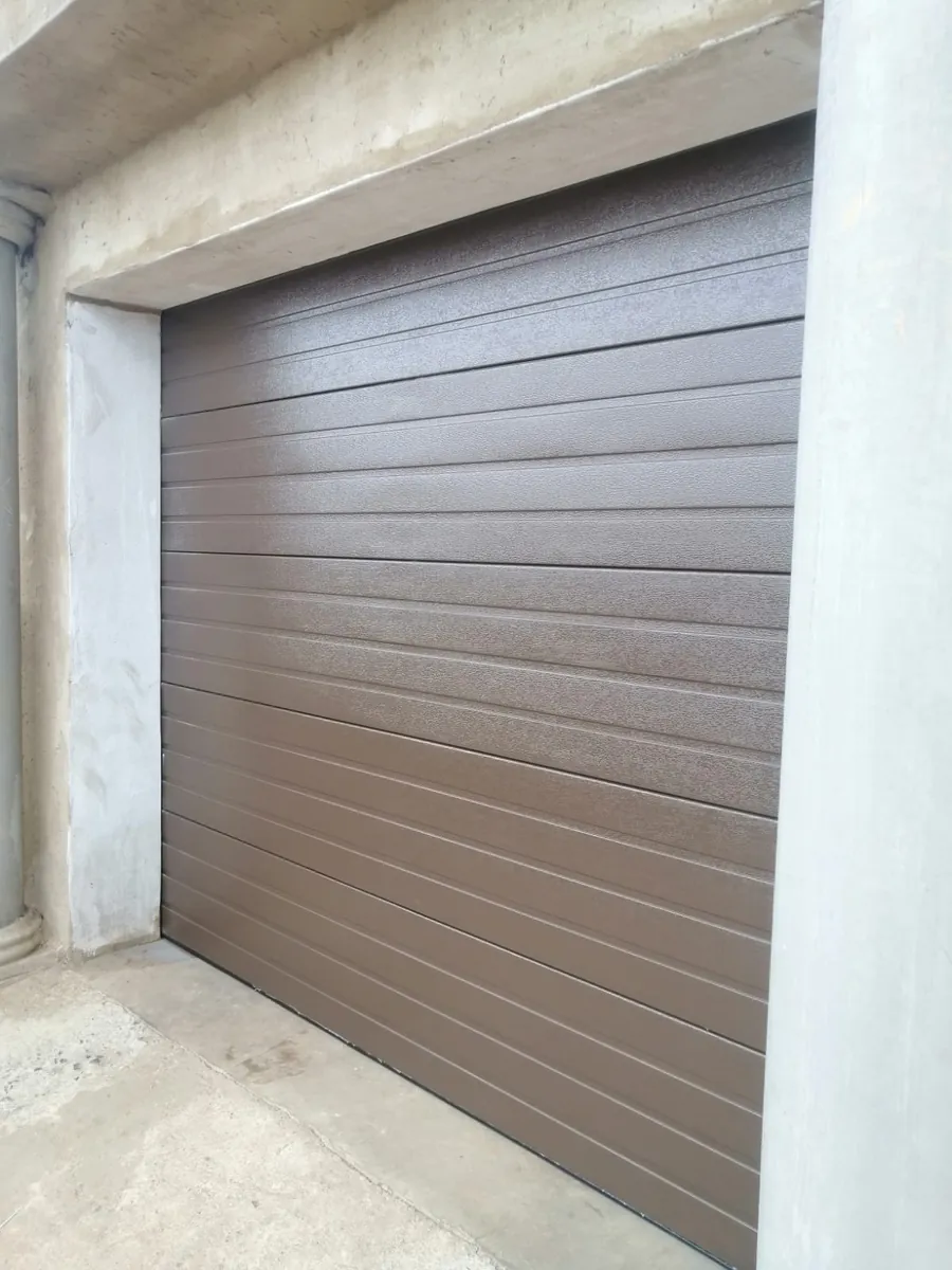 Brown horizontal sectional garage door installed at a property