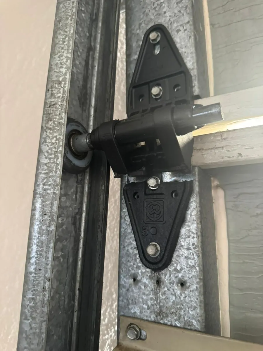 Close-up of a garage door side roller hinge and steel track