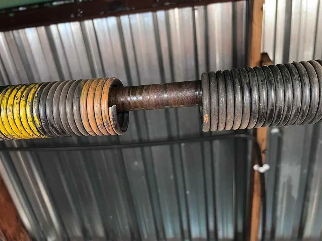 Close-up of a garage door torsion spring and shaft from our project photos
