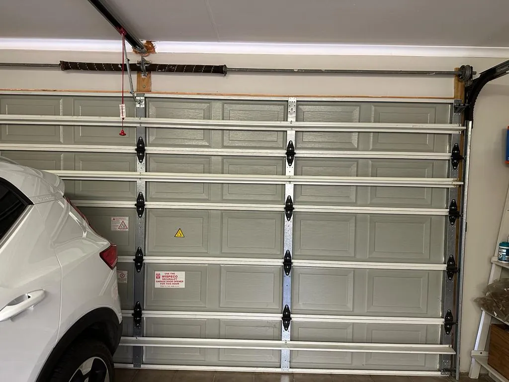 Inside of a steel sectional garage door with panels, hinges and tracks