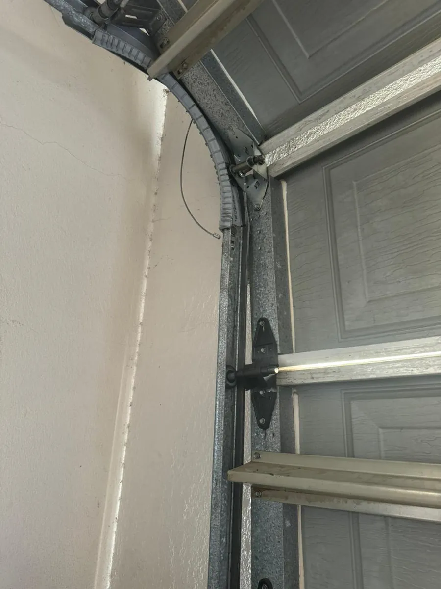 Curved track and roller arrangement on a sectional garage door