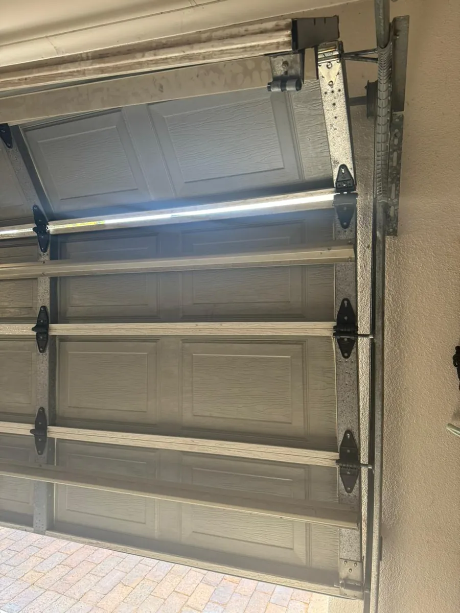 Steel sectional garage door panels and hinges