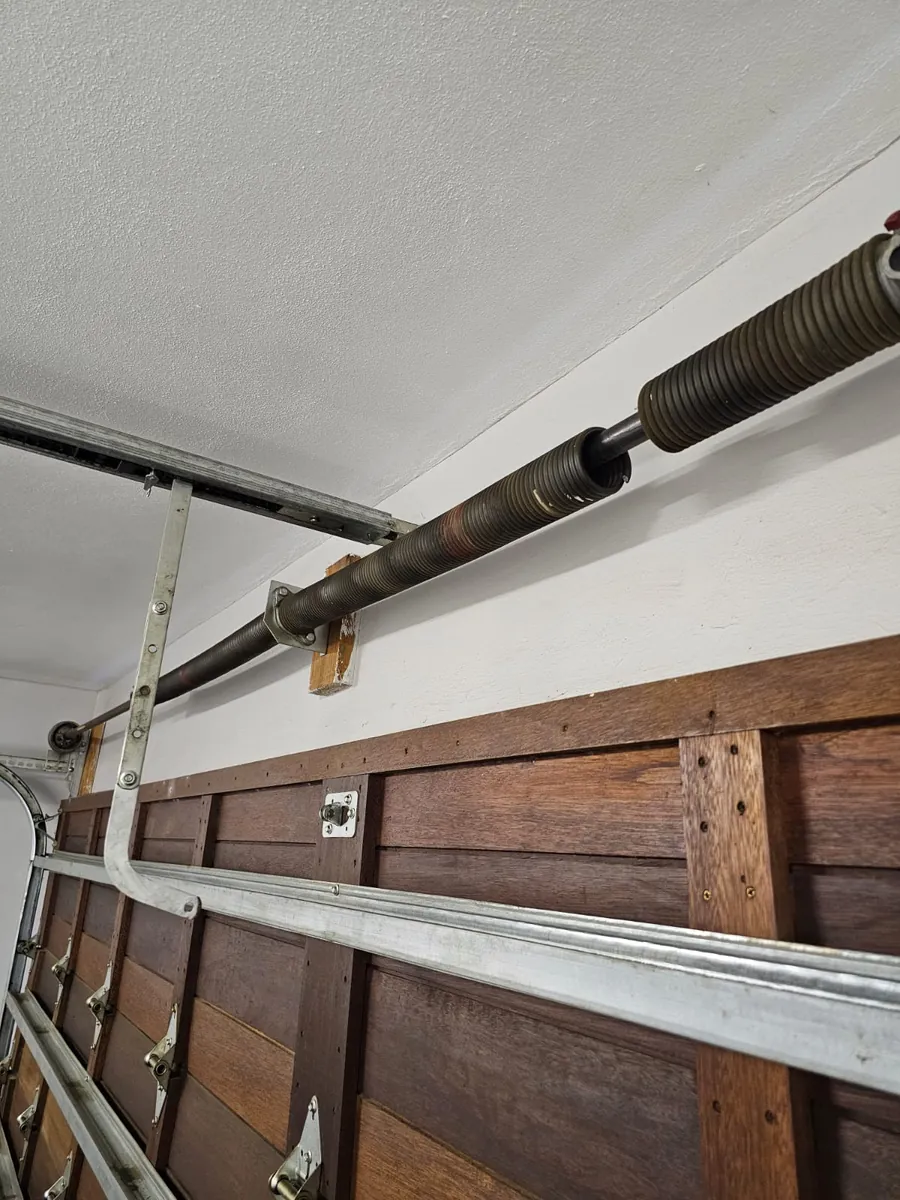 Wooden garage door spring and reinforcement rail