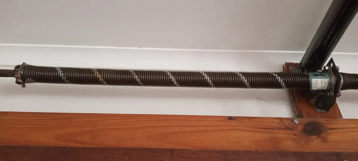 Wooden garage door torsion spring and cable drum
